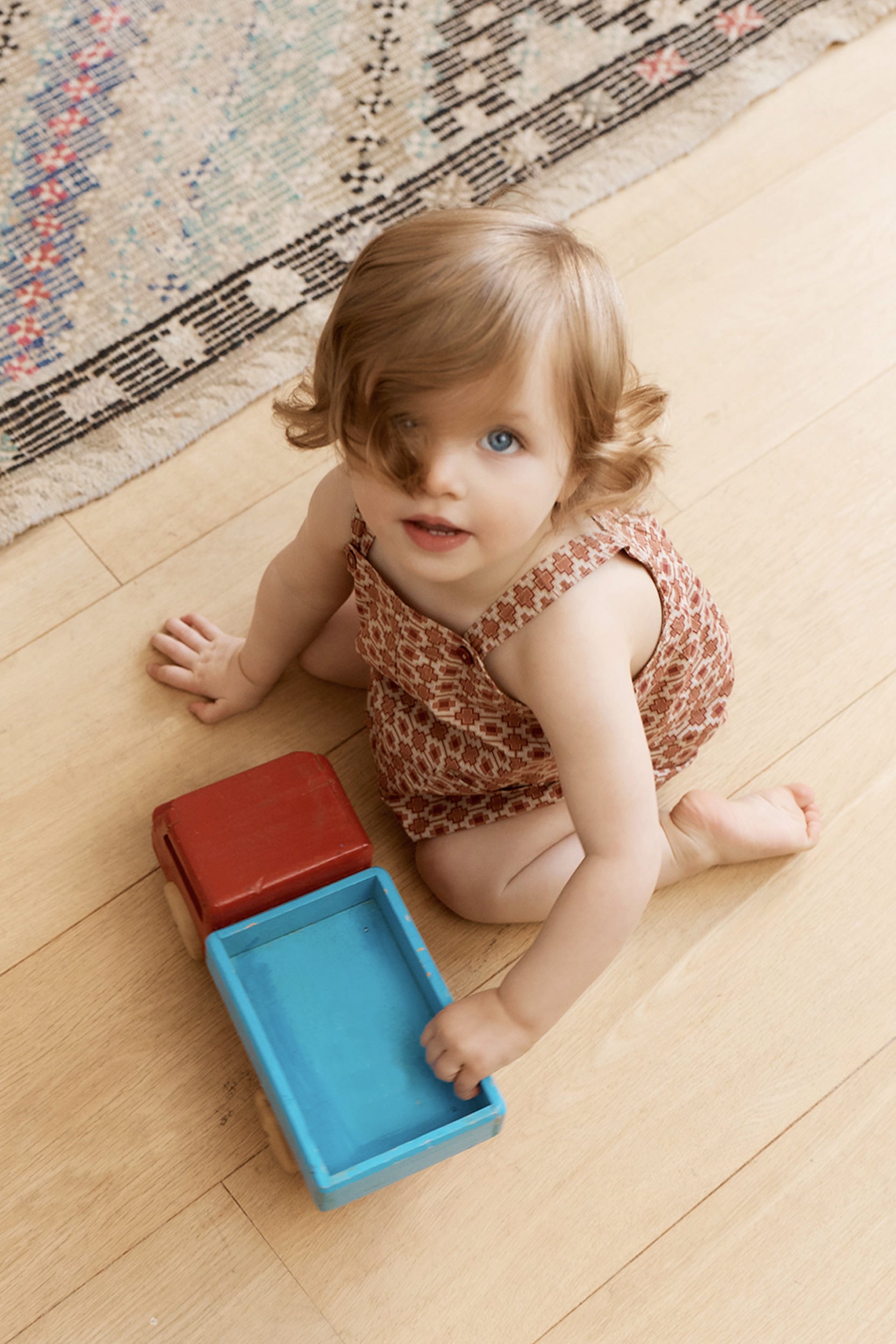 Child playing with colorful blocks on a wooden floor